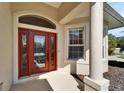 Close-up of elegant red front door with decorative glass and neutral-toned exterior at 6907 Eagle Ridge Blvd, Lakeland, FL 33813