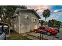 Charming home featuring a two-car garage, red sedan, and tasteful awnings over the upstairs windows at 723 W Patterson St, Lakeland, FL 33803
