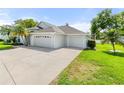 Beautiful one-story home with a well-maintained lawn, mature landscaping, and a three-car garage at 117 Belmont Dr, Winter Haven, FL 33884