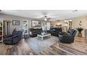 Spacious living room with wood-look floors, ceiling fan, and comfortable seating, creating a cozy and inviting space at 1311 Glengreen Ln, Lakeland, FL 33813