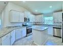 Gourmet kitchen boasts stainless steel appliances, granite countertops and a spacious center island at 1588 Leamington Ln, Winter Haven, FL 33884