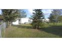 Picture of a well-kept backyard with green grass, trees, and view of other homes at 1610 Reynolds Rd # 239, Lakeland, FL 33801