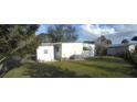 Fenced backyard area showing well-maintained lawn, trees and the exterior of the home at 1610 Reynolds Rd # 239, Lakeland, FL 33801