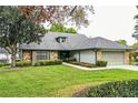 Charming single-story home with stone accents, well-maintained lawn, and mature trees at 1842 Pinnacle Dr, Lakeland, FL 33813