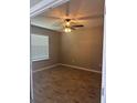 An empty bedroom featuring wood-style tiled flooring, neutral walls, and a ceiling fan at 1921 Bell Creek Loop, Fruitland Park, FL 34731