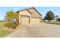 Spacious three-car garage and driveway surrounded by lush green lawn, ample parking for residents and visitors at 2210 Moraine Ct, Lakeland, FL 33805