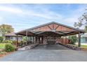 Inviting brick carport features stylish wooden accents and provides sheltered parking, adding curb appeal to the property at 27836 Lois Dr, Tavares, FL 32778