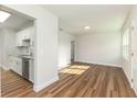 Bright living room leads into kitchen, featuring wood flooring, white interior and natural light at 2924 Bellwood Ave, Lakeland, FL 33803