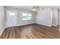 Spacious living room features wood floors, large window and modern ceiling fan at 300 Senate St, Auburndale, FL 33823