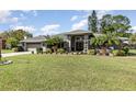 Charming single-story home featuring a manicured lawn, palm trees, and a neatly landscaped garden at 3001 Plantation Rd, Winter Haven, FL 33884