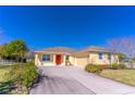 Charming one-story yellow home with a red front door, well-manicured landscaping, and a welcoming driveway at 3533 Britt Rd, Mount Dora, FL 32757