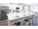 Modern kitchen with white cabinets, stainless steel appliances, and a large center island with bar stool seating at 4374 River Birch Bnd, Lakeland, FL 33811