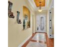 Inviting foyer featuring decorative sconces, elegant tile flooring, and a glass-paneled front door at 4759 Lathloa Loop, Lakeland, FL 33811