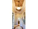 Elegant hallway with decorative ceiling, tiled floor, and arched doorway, creating a grand entrance at 4759 Lathloa Loop, Lakeland, FL 33811