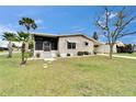 Charming single-story home with a well-manicured lawn, a carport, and a screened in porch at 4985 Deerwood Dr, Lakeland, FL 33810