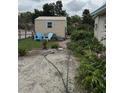 Backyard shed with blue chairs, surrounded by trees and foliage at 5636 Old Highway 37, Lakeland, FL 33811