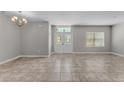 Bright living room showcasing tile floors, fresh paint, and a decorative chandelier at 6185 Gracie Pl, Lakeland, FL 33812