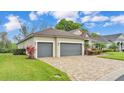 Beautiful home featuring an attached two-car garage, manicured lawn, and mature landscaping at 6923 Highlands Creek Ave, Lakeland, FL 33813