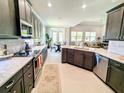 Open-concept kitchen with stainless steel appliances and bar-height seating for casual dining at 7903 Lake James Blvd, Lakeland, FL 33810