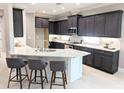 Modern kitchen featuring dark cabinetry, granite countertops, and a breakfast bar with seating at 7903 Lake James Blvd, Lakeland, FL 33810