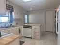 Efficient kitchen featuring wood countertops, white appliances, and tile flooring at 1007 Forest Lake Dr, Lakeland, FL 33809