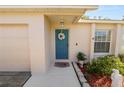 Inviting home entrance featuring a blue front door adorned with a wreath and a 'welcome' mat at 1021 Meadowood Pointe Rd, Lakeland, FL 33811