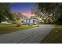 Exterior view of home with gravel driveway, showcasing landscaping and curb appeal at 1115 S Virginia Ave, Bartow, FL 33830