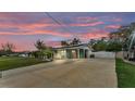 Charming single-story home at dusk featuring a covered entrance, vibrant turquoise accents, and a spacious driveway at 1160 Ilene Ave, Bartow, FL 33830