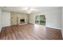 Open living room with a brick fireplace, wood floors, and sliding glass doors at 1310 Walt Williams Rd, Lakeland, FL 33809