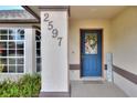 Close-up of the home's entrance, featuring a decorative door with address numbers and surrounding foliage at 2597 Highlands Vue Pkwy, Lakeland, FL 33812