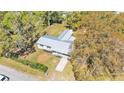 Aerial view showcasing the home's layout, metal roof, spacious yard, and surrounding greenery at 3035 Linda Dr, Lakeland, FL 33810