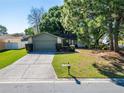 Charming single-story home featuring a well-maintained lawn and an attached two car garage at 3823 Woodburn E Loop, Lakeland, FL 33813