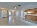 Open-concept living space with tile floors, ceiling fan, and combined kitchen and dining areas at 3823 Woodburn E Loop, Lakeland, FL 33813