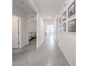 Hallway with art leading to a bedroom and an open living space with neutral paint and ceramic tile floors at 3843 Resting Robin Ave, Bartow, FL 33830