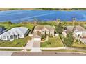 Serene view of a two-story home with a vast backyard and stunning lake access at 4512 Brookshire Pl, Lake Wales, FL 33898