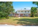 Charming two-story home with a brick facade, white shutters and a well-maintained front yard and lush landscaping at 4908 S Bedford Ln, Lakeland, FL 33813