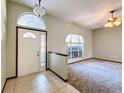 Inviting foyer with neutral tile flooring, an arched transom window, and entry into a spacious living area at 5730 Tanasi Ct, Lakeland, FL 33812