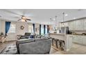 Living room and kitchen featuring bar top seating, stainless steel appliances, and backyard views at 5798 Dornich Dr, Auburndale, FL 33823