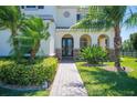 Inviting front entrance featuring arched doorways, stone accents, and lush greenery, creating a welcoming ambiance at 6515 Eagle View Loop, Lakeland, FL 33813