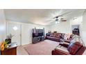 Comfortable living room featuring a ceiling fan, tv, leather sectional, and light color wood flooring at 6525 Glen Meadow Dr, Lakeland, FL 33810