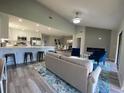 Bright, open-concept living room flows into modern kitchen with white cabinets and stainless steel appliances at 692 Augusta Rd, Winter Haven, FL 33884