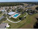 Aerial view of community pool, tennis court, and surrounding homes at 726 Chacall Loop, Mount Dora, FL 32757