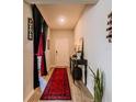 Inviting entryway with a red rug, table, and unique theater-themed decor at 7289 Liberty Rd, Lakeland, FL 33809