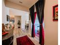 View of the hallway with a decorative table, hardwood floors and theater-themed curtains at 7289 Liberty Rd, Lakeland, FL 33809