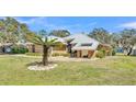 Beautiful house with a distinctive metal roof, stone details, and a mature palm tree in the yard at 8621 Plantation Ridge Blvd, Lakeland, FL 33809