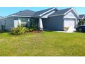 Charming single-story home with a well-manicured lawn, tidy landscaping, and a one car garage at 925 First Dr, Eagle Lake, FL 33839
