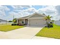 Inviting single-story home with a two-car garage, lush landscaping, and a well-maintained front lawn at 937 Montgomery Ln, Polk City, FL 33868