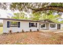 Charming one-story home with a white brick exterior, complemented by dark shutters at 135 Kenilwood Ln, Lakeland, FL 33809