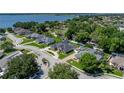 Aerial view of a home near the lake with a screened-in pool, beautiful landscaping, and circular driveway at 152 Melissa Trl, Auburndale, FL 33823