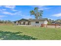 Beautifully landscaped ranch home featuring a covered front porch with rocking chairs and a spacious lawn at 1535 Walker Rd, Lakeland, FL 33810